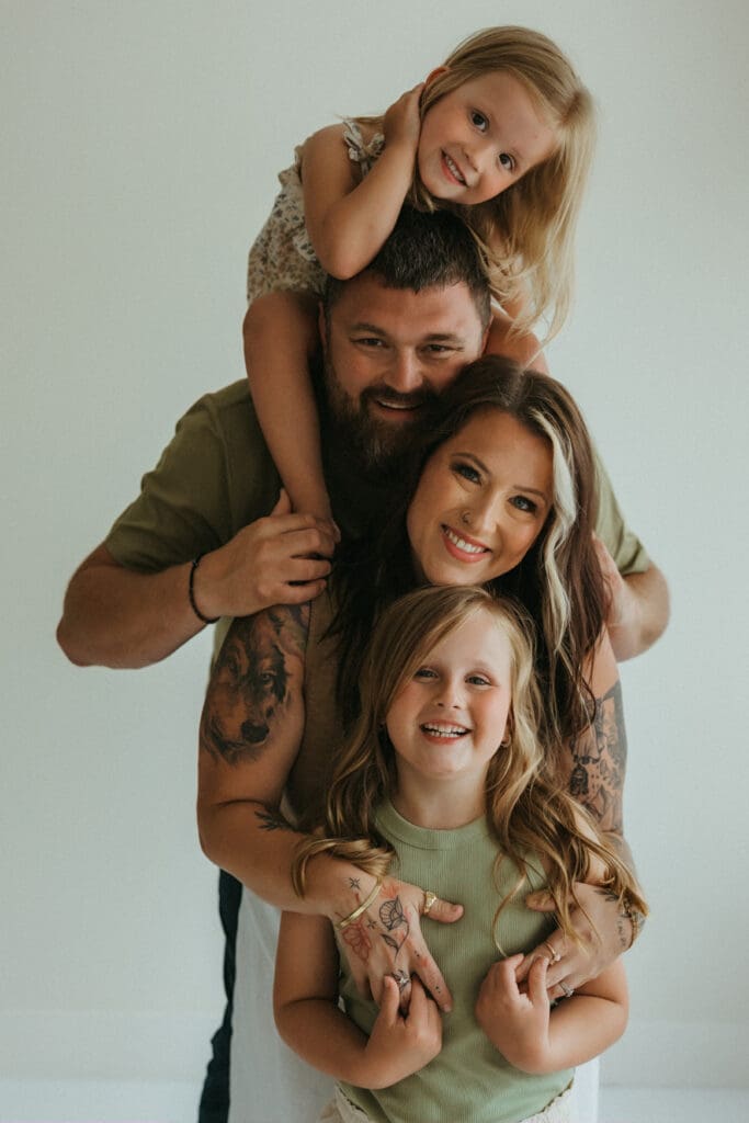 family smiling at camera in a studio