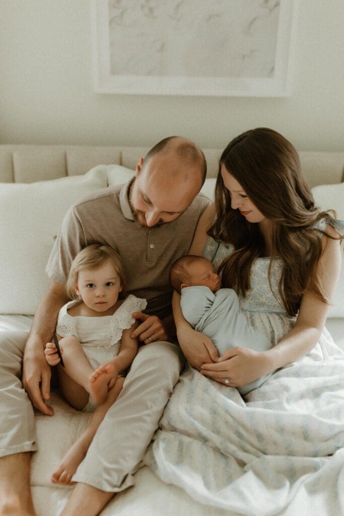 family in bed during newborn photoshoot 