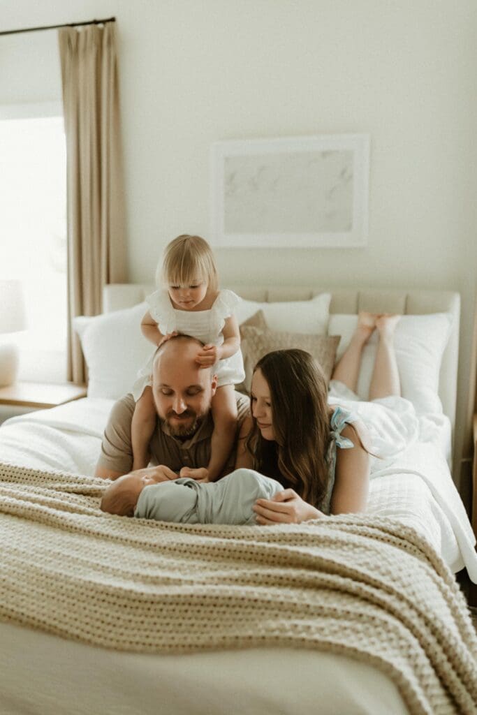 candid family photo on bed in south bend newborn photography session