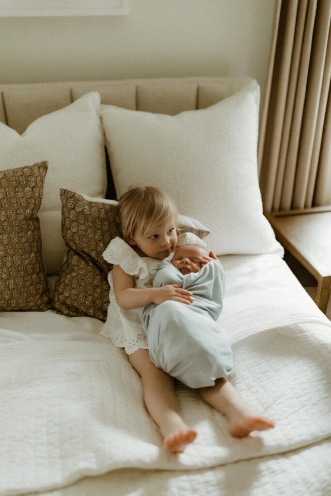 sister and newborn baby during candid moment in south bend