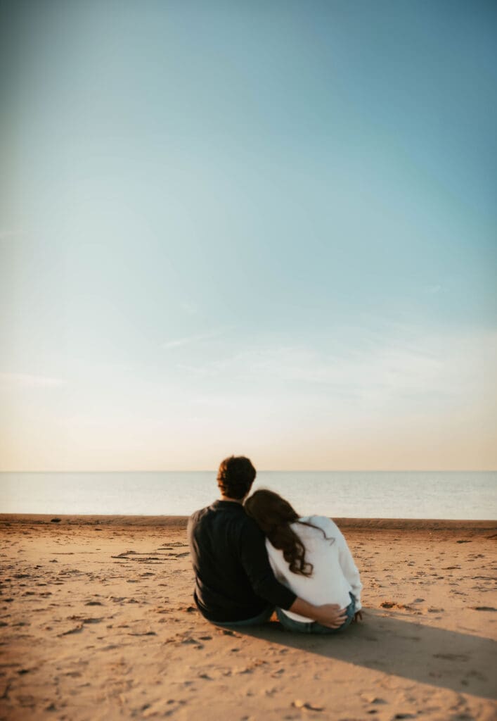 couple watching the sunset on new buffalo beach