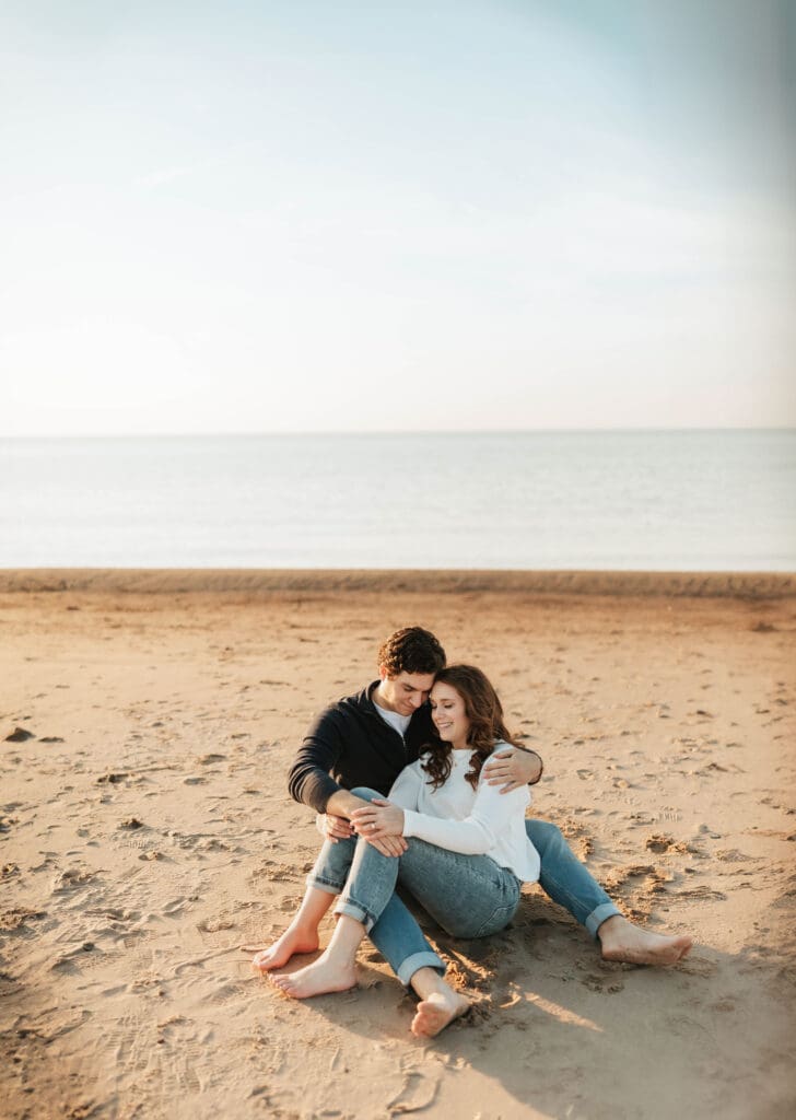 couple sitting together along shoreline in new buffalo
