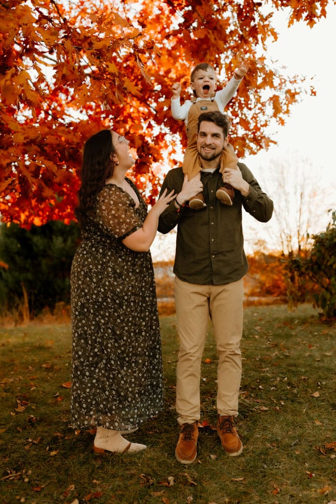 toddler and parents posing outside during photo session