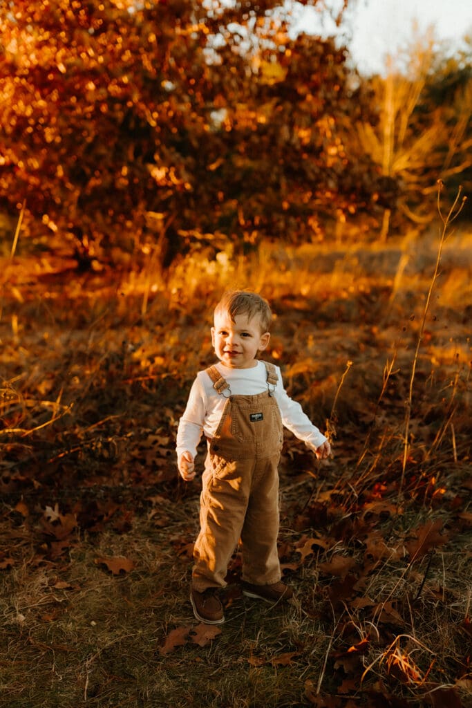 child playing outside during photoshoot in the fall