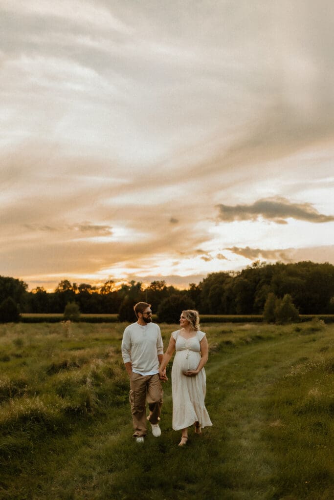 couple walking together and holding hands and baby belly