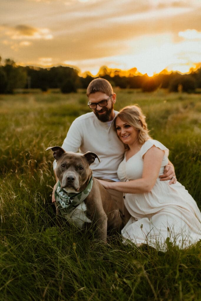 pitbull and couple in field photography