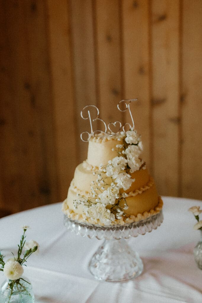 wedding cake with flowers and bride and grooms initials