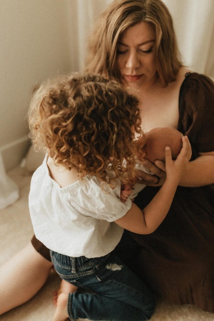 candid photo of baby and sister in a studio