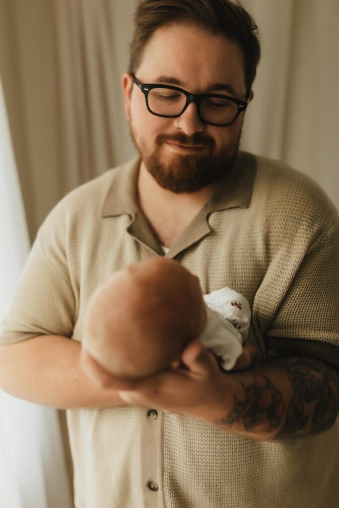 smiling dad at baby in studio