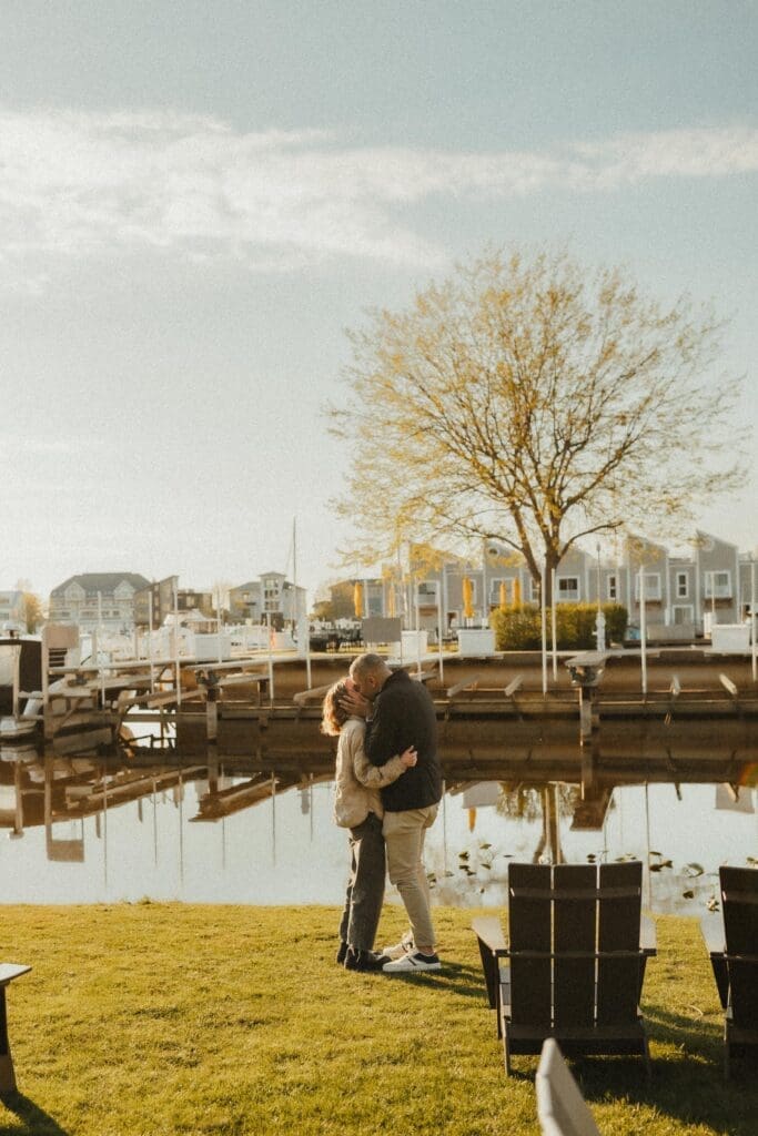 couple kissing by the lake during proposal photos