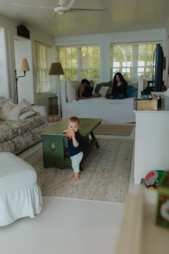 candid photograph of a baby walking inside a house during photoshoot
