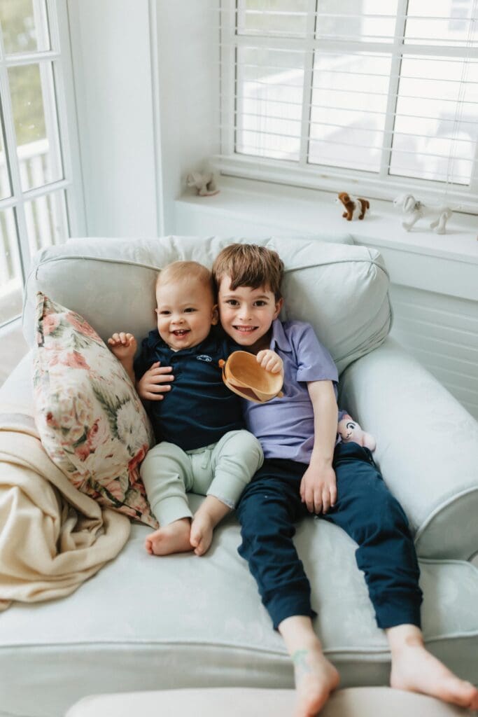 sibling photograph taken on a chair indoors at family photoshoot in unior pier 